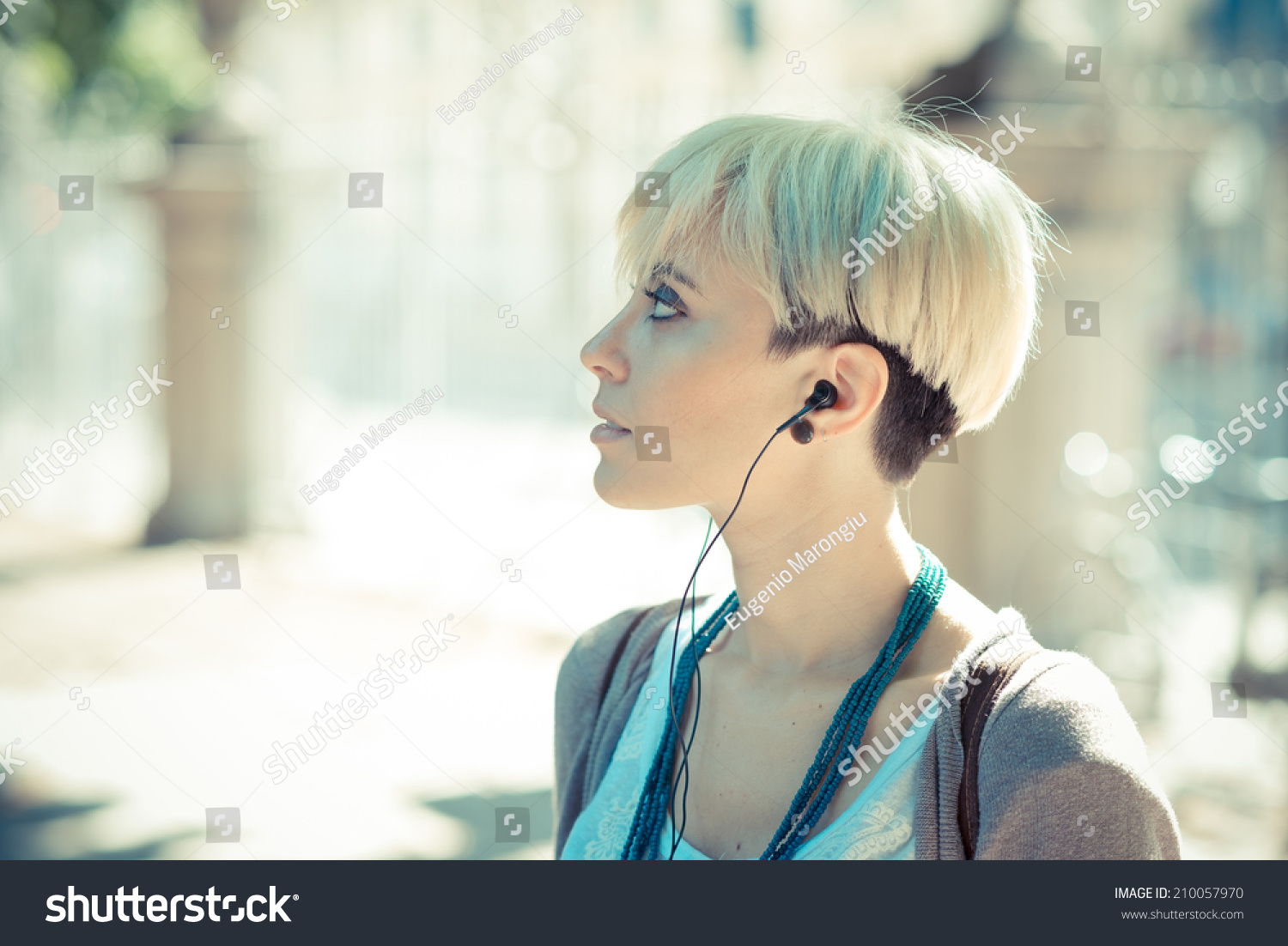 年轻美丽的金色短发的女人听音乐耳机-人物-海