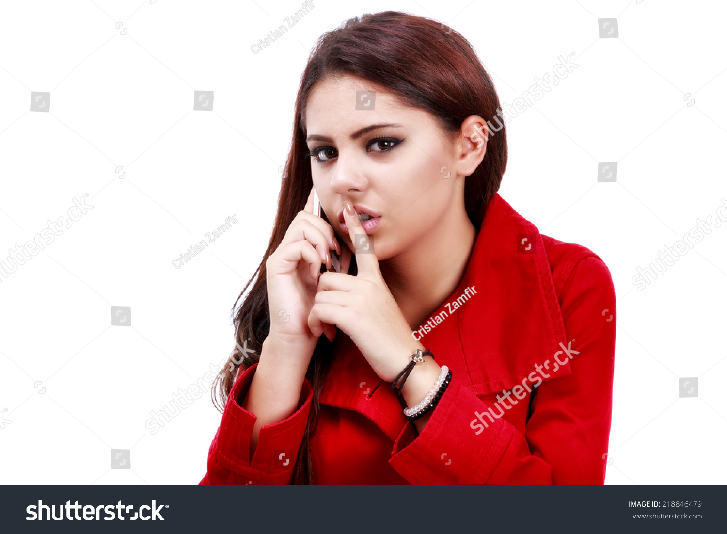 年轻的商业妇女做嘘的手势在电话