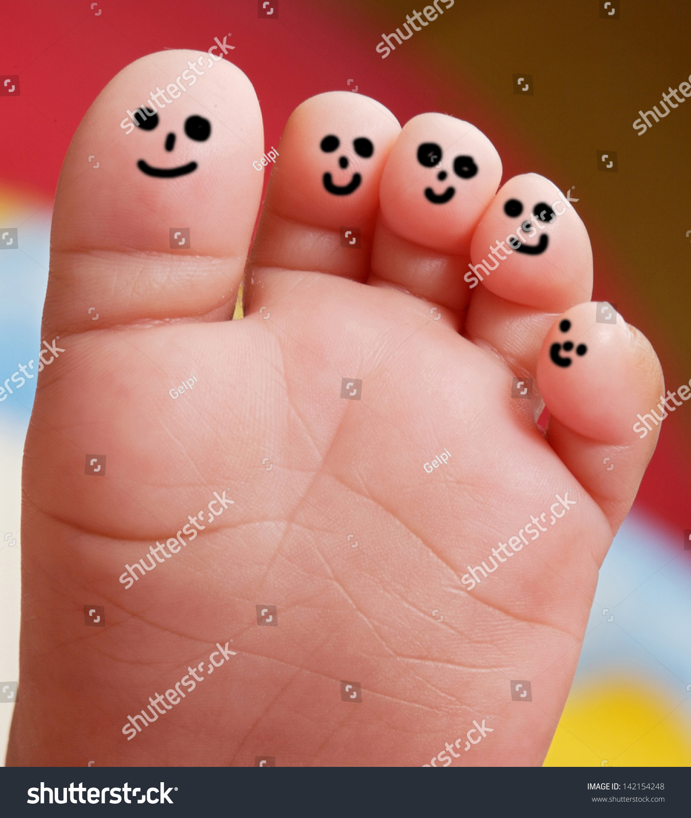 漂亮的婴儿用笑脸彩绘的脚趾