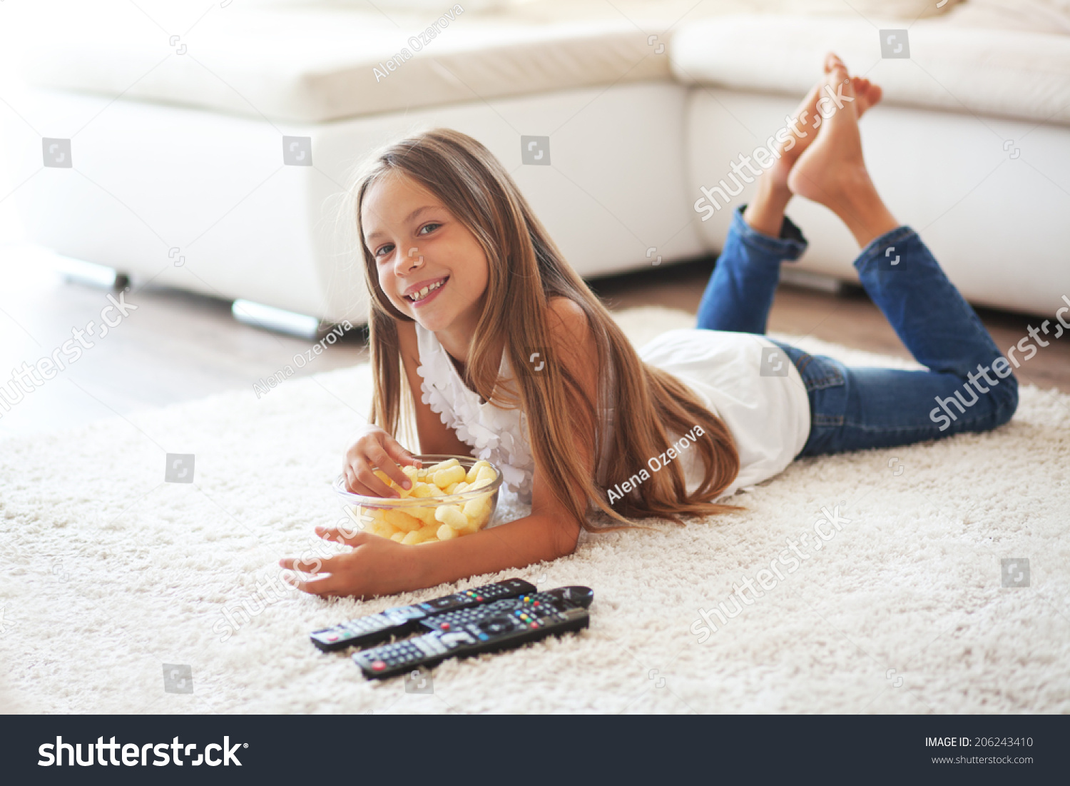 8岁孩子看电视躺在白色的地毯上独自在家